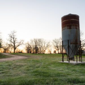 A large metal tank in the middle of a field.