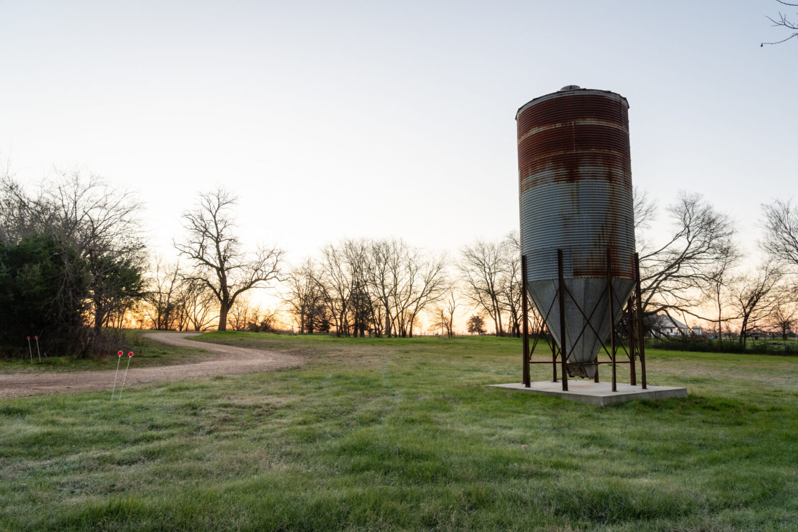 A large metal tank in the middle of a field.